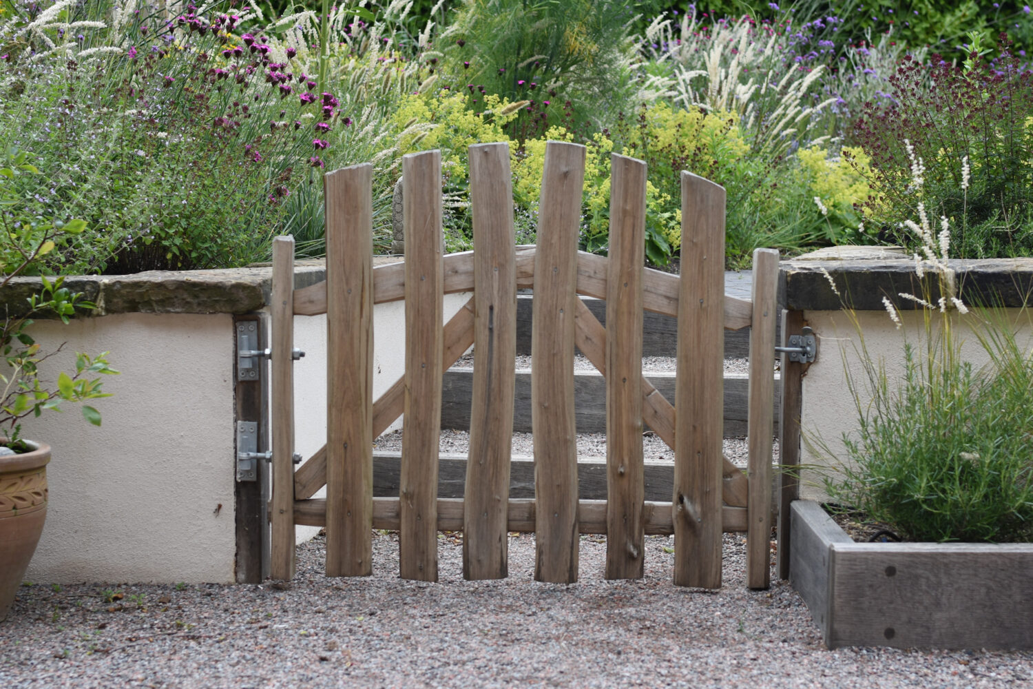 Handcrafted Chestnut wood gate in naturalistic garden 