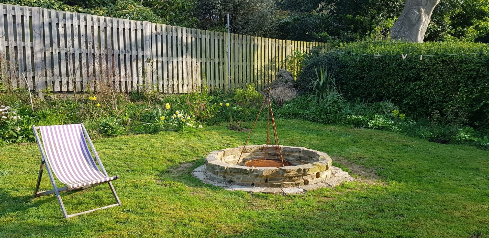 reclaimed stone fire pit in middle of garden