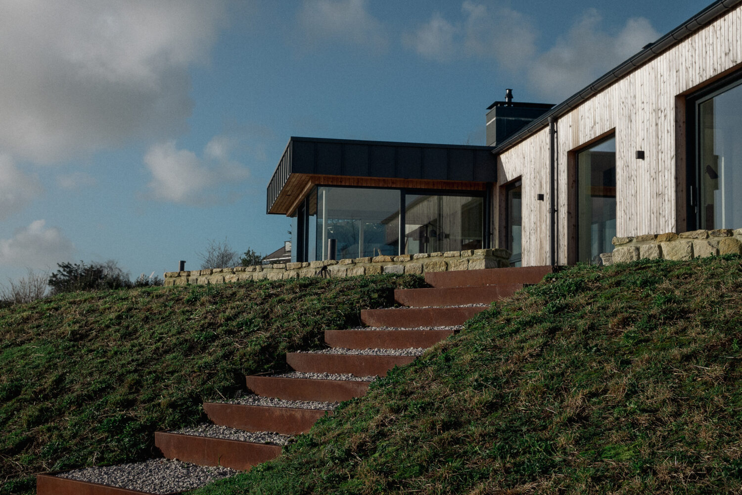 Corten steel steps within a wildflower meadow bank