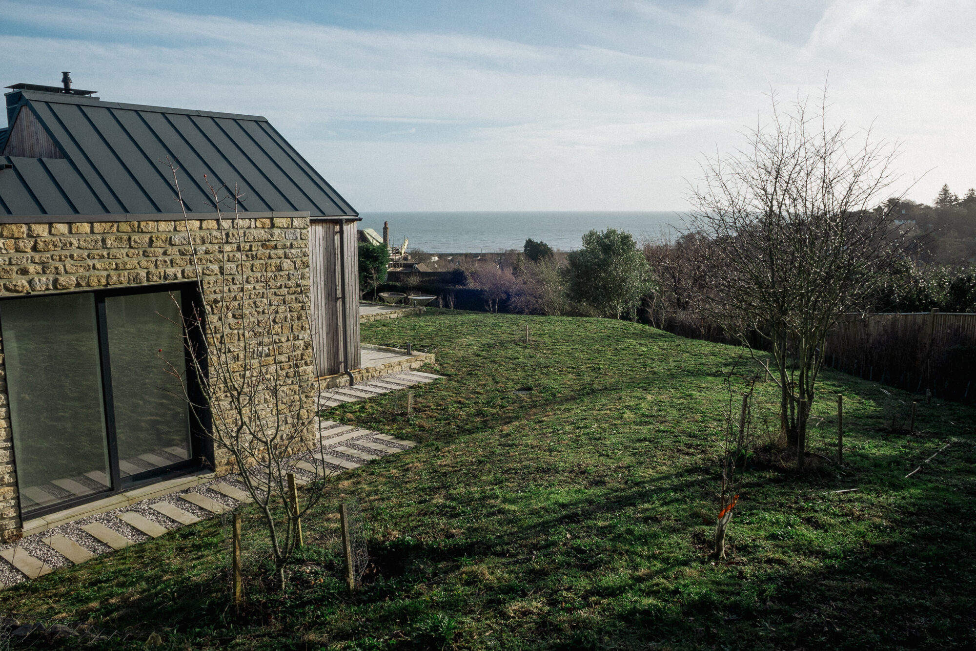 Wildflower meadow next to a contemporary house overlooking the sea